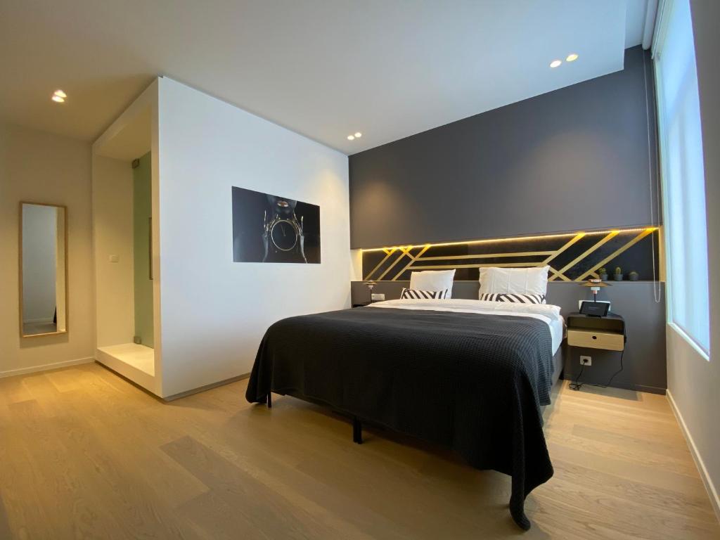 a bedroom with a bed with a black and gold headboard at Smartflats - Fashion in Brussels