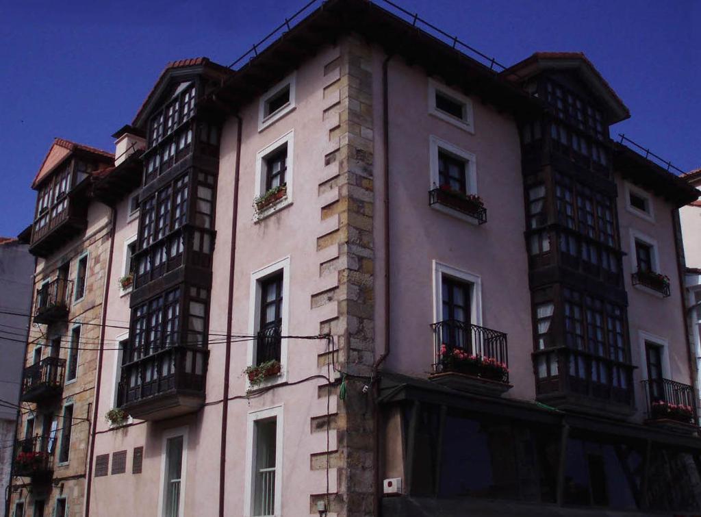 un edificio alto con balcones a un lado. en Apartamentos Ebro Reinosa en Reinosa