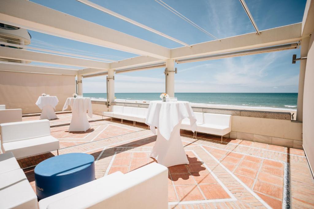 a dining room with a view of the ocean at Hotel Playa Victoria in Cádiz