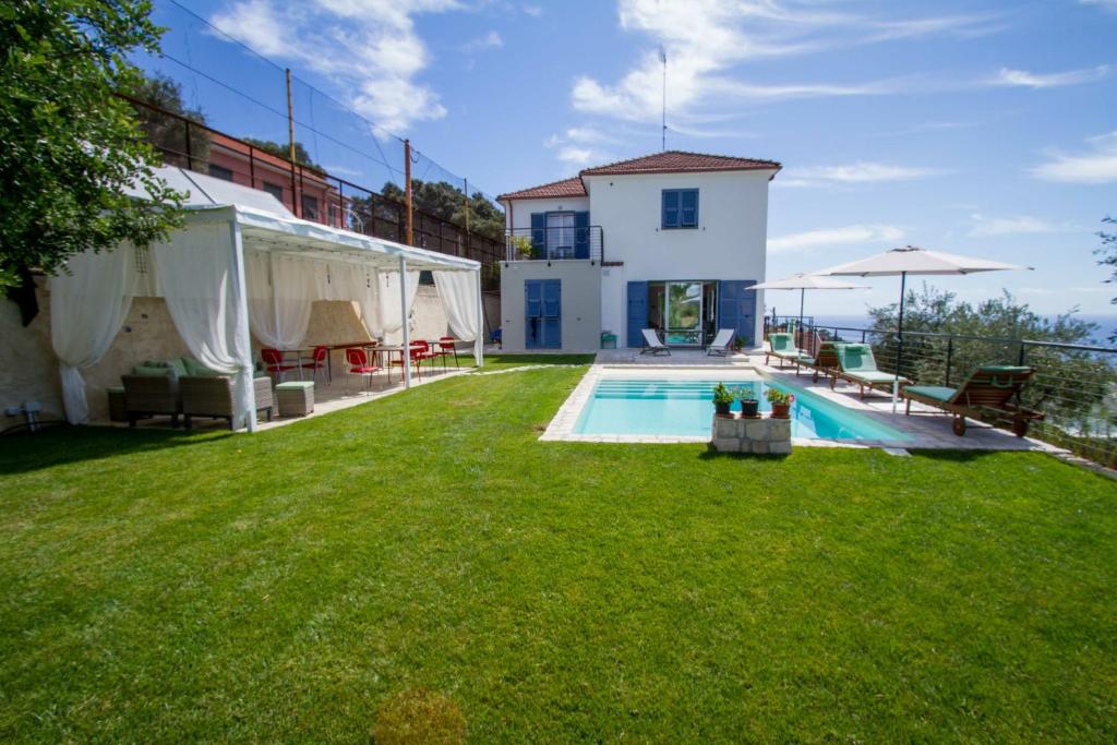 a backyard with a swimming pool and a house at Il Sole di Poggi in Imperia