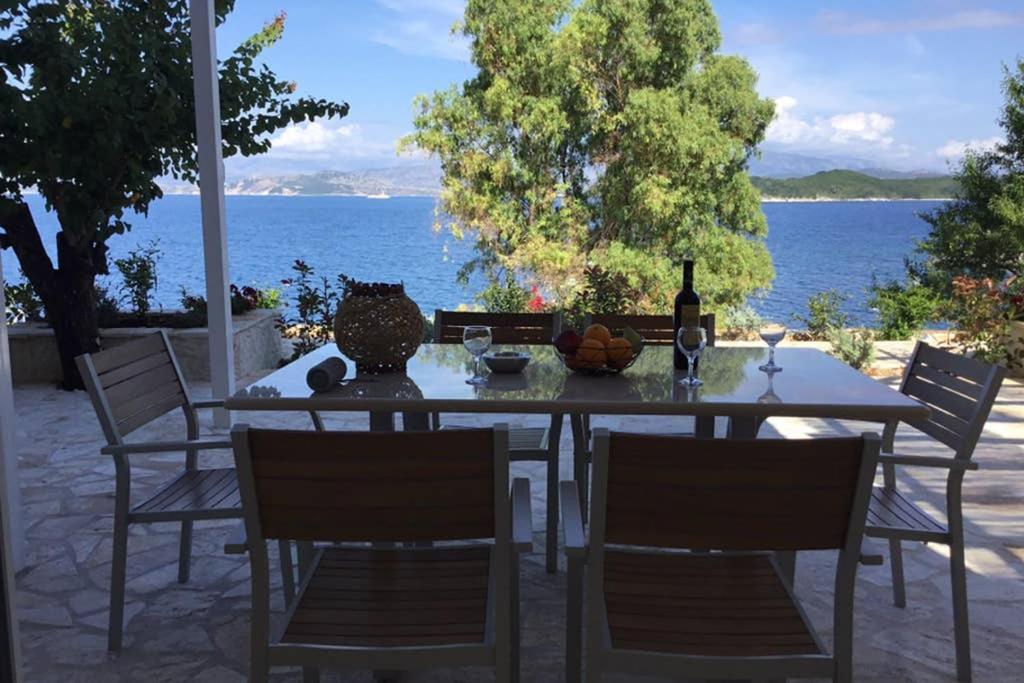 - une table avec des chaises et une bouteille de vin dans l'établissement Corfu island KASSIOPI’S best sea view apartment, à Kassiopi