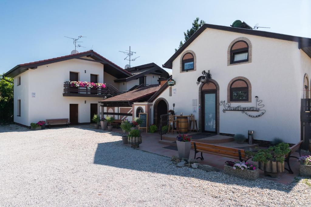 a white house with a bench in front of it at RESTAURACE A PENZION U DOUBKŮ in Břeclav