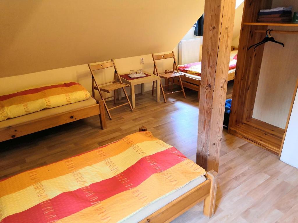 a room with two bunk beds and a table and chairs at Hostel Skautský dom in Banská Štiavnica