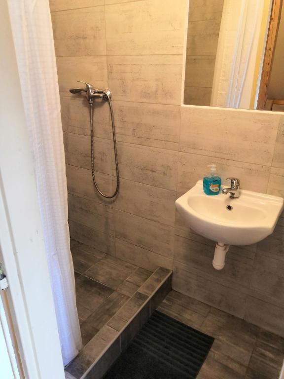 a bathroom with a sink and a shower at Hostel Skautský dom in Banská Štiavnica