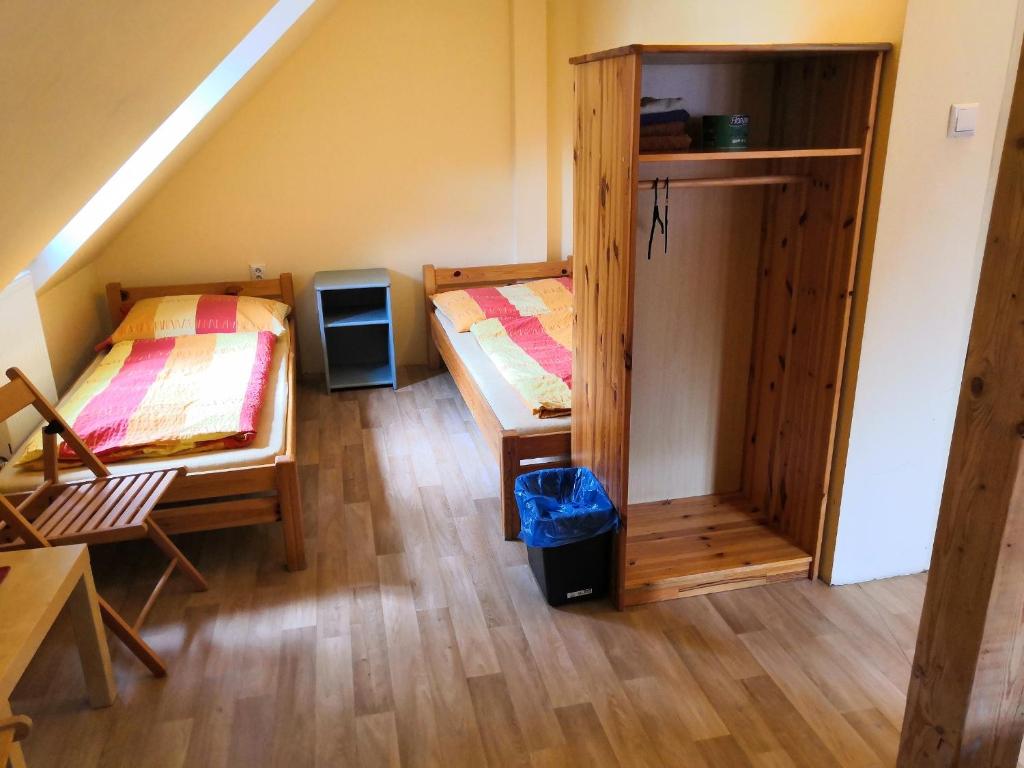 a room with two beds in a room with a staircase at Hostel Skautský dom in Banská Štiavnica