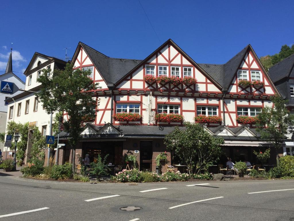 un grand bâtiment rouge et blanc sur le côté d'une rue dans l'établissement Hotel Garni Maaß, à Braubach