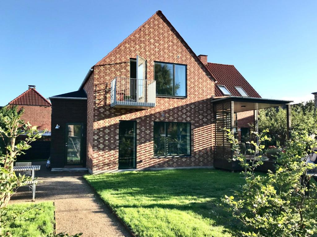 a brick house with a balcony on a lawn at Villa Stjerneklar in Copenhagen