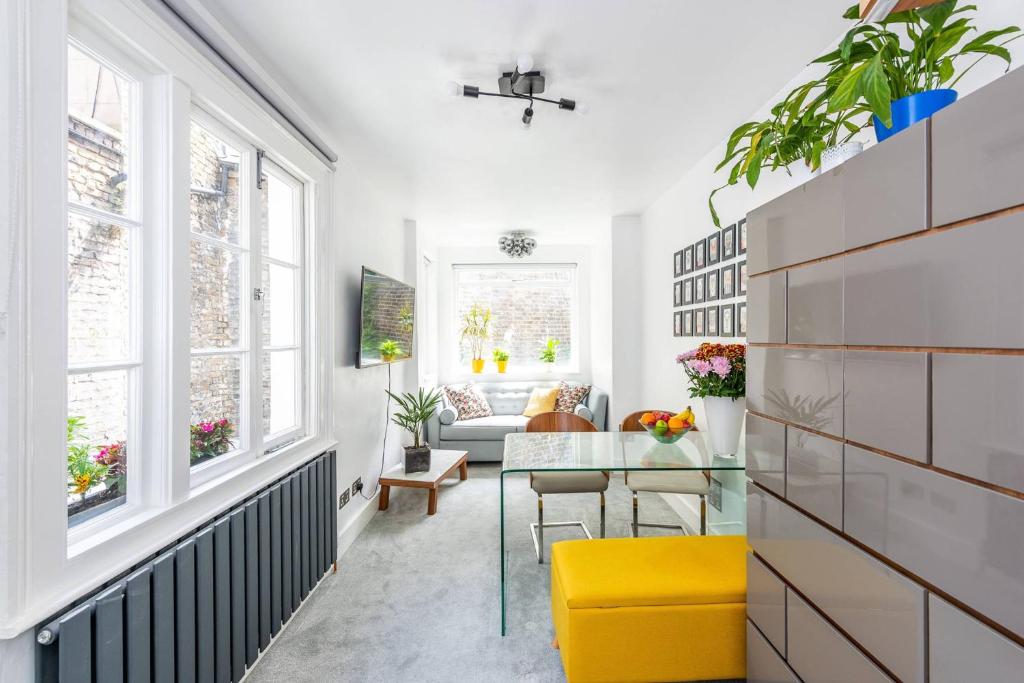 a living room with a yellow chair and a glass table at Bright, brand new 1 Bed Flat Central London in London