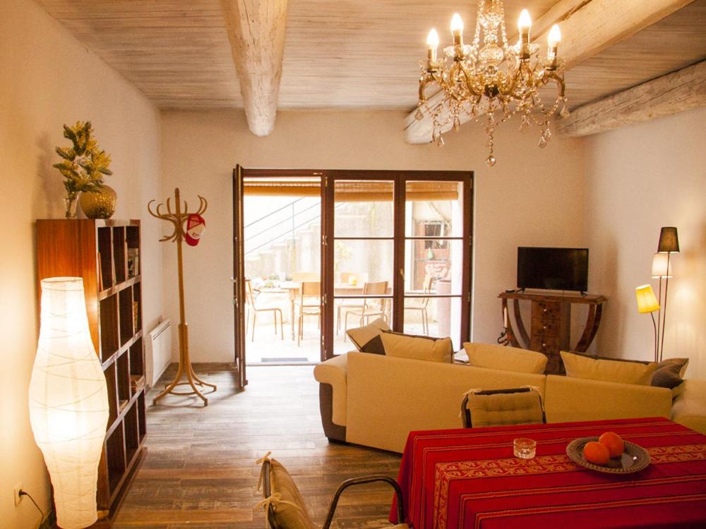 - un salon avec un canapé et un lustre dans l'établissement Les fenêtres sur cour, à Pézenas