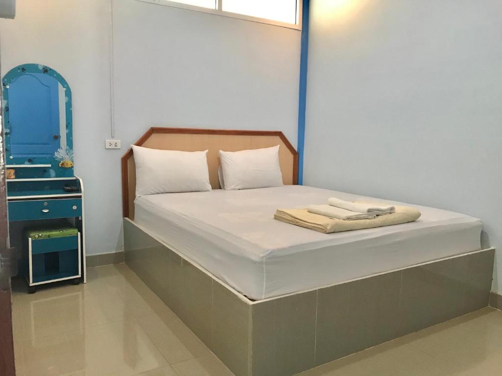 una camera da letto con un letto con uno specchio sopra di Tanarod Gueshouse a Suratthani