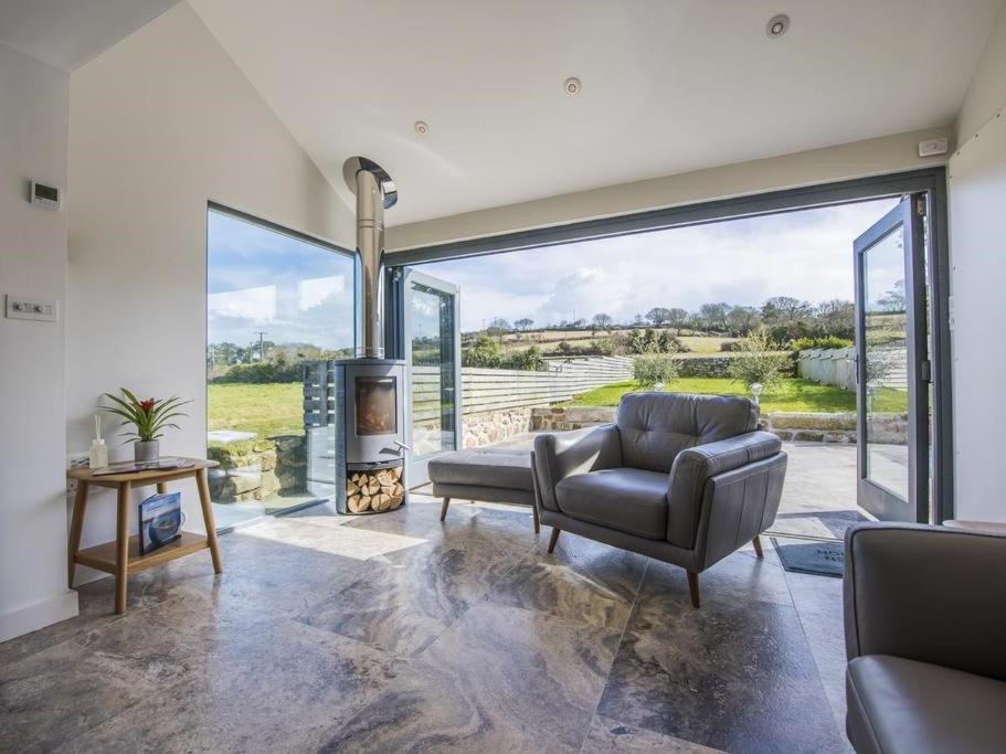 a living room with a couch and a chair and a fireplace at chyreen@marazion in Marazion