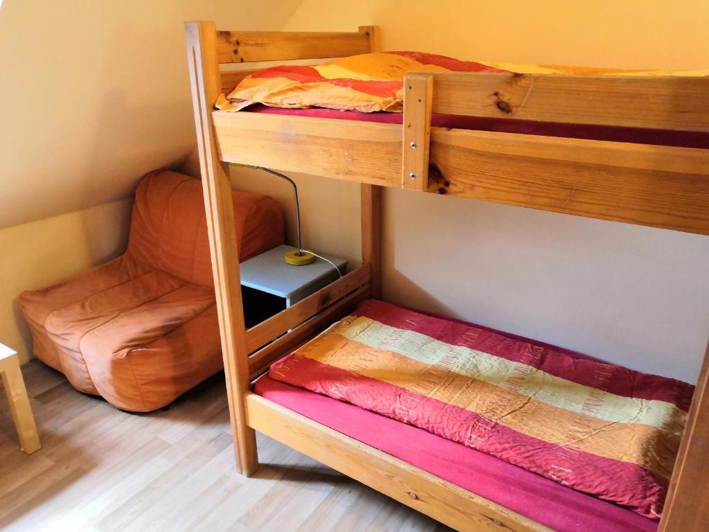 a bunk bed room with two bunk beds and a chair at Hostel Skautský dom in Banská Štiavnica