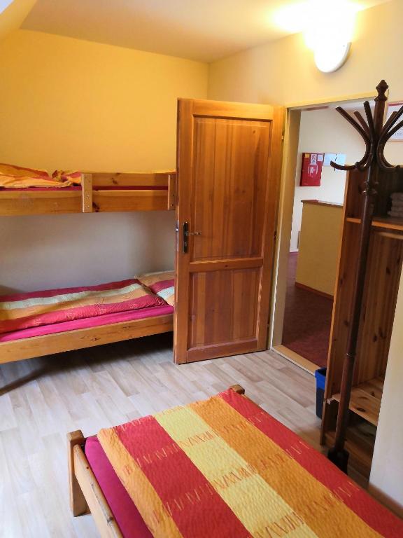 a room with two bunk beds and a door at Hostel Skautský dom in Banská Štiavnica