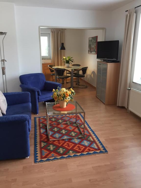 sala de estar con sofá azul y mesa en Messewohnung Düsseldorf-Nord, en Düsseldorf