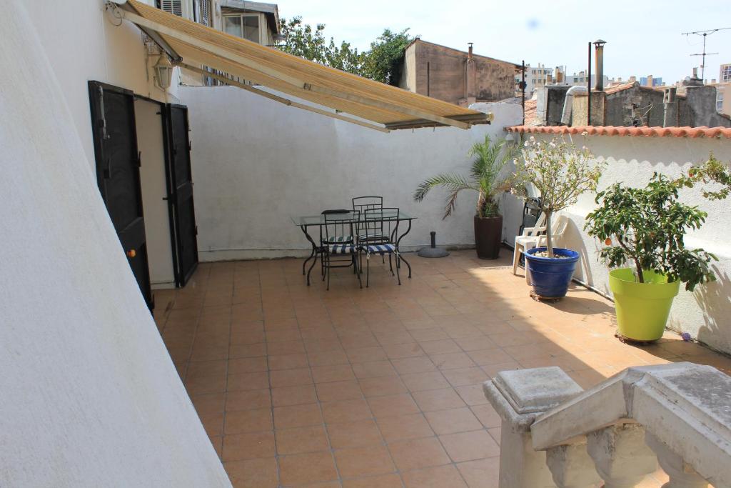 un patio avec une table et des chaises sur un bâtiment dans l'établissement Maison 3 chambres gde terrasse proche vieux port et sncf, à Marseille