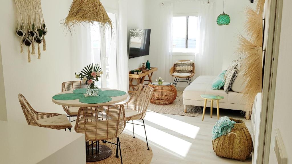 Suit Mar y Sol في كالا راتخادا: غرفة معيشة مع طاولة وكراسي