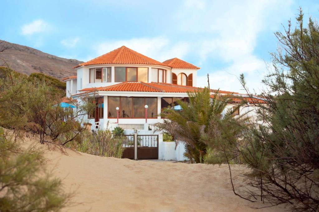 een huis met een oranje dak op een strand bij Theresia's in Porto Santo