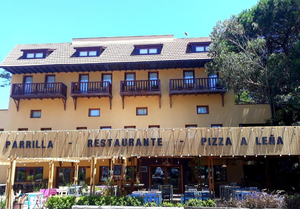 un hotel con un cartel que lee el restaurante pandilla y la liga de pizza en La Tavola Hotel, en Pinamar
