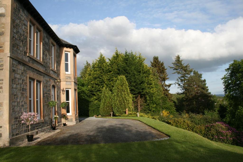 a driveway leading to a house with a garden at Arrandale House in Pitlochry