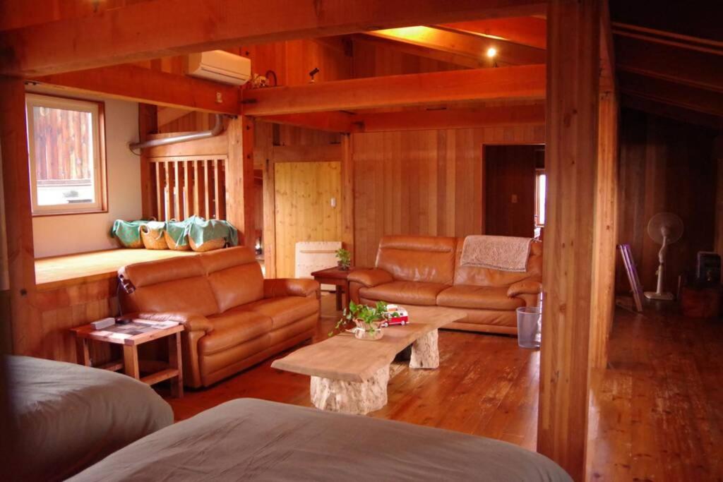 a living room with leather furniture and a couch at Miyajima Breeze in Hatsukaichi