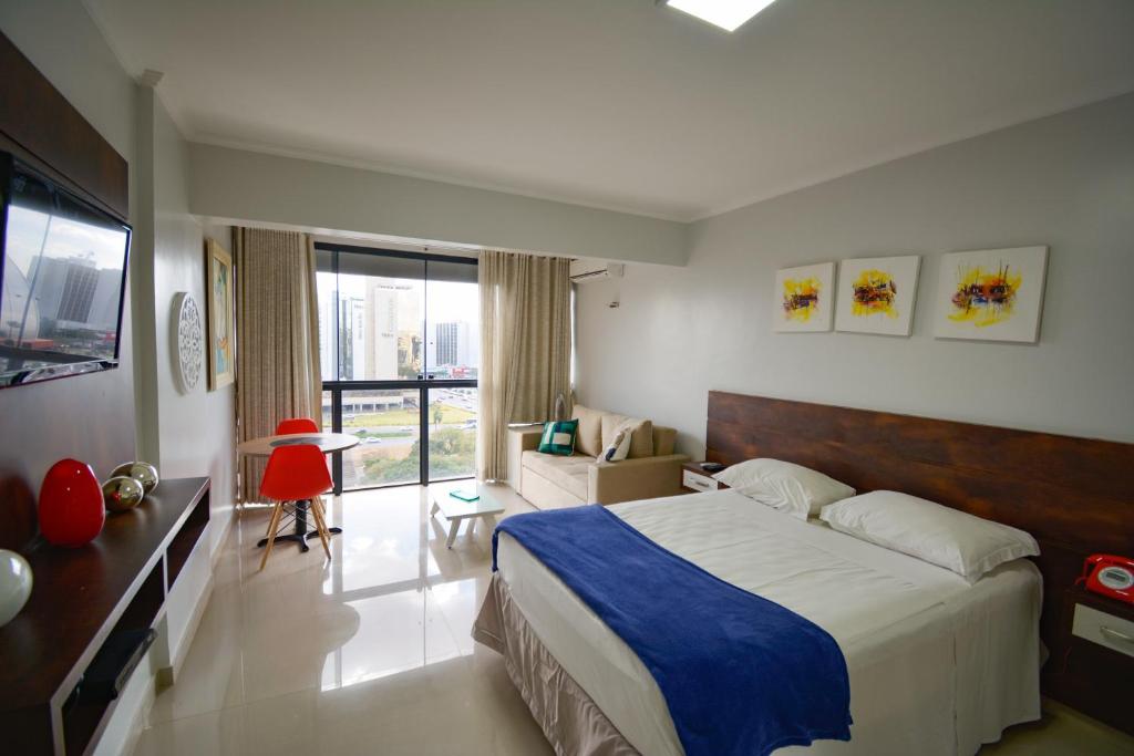 ein Schlafzimmer mit einem großen Bett und einem großen Fenster in der Unterkunft Garvey Park Hotel in Brasilia