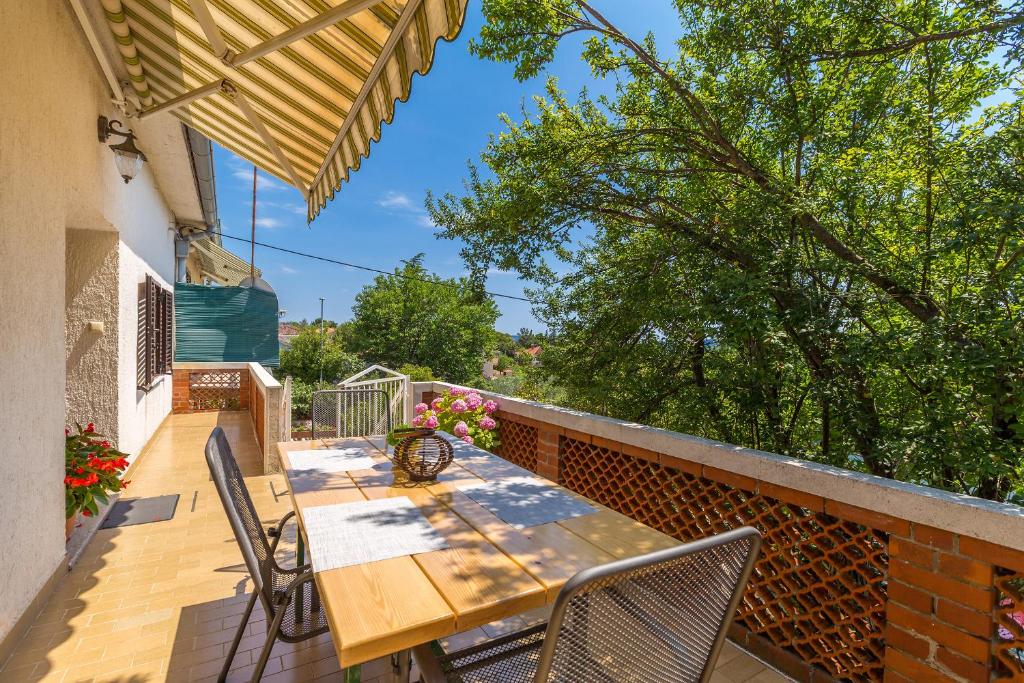 a wooden table and chairs on a balcony at Apartments Krc in Pinezici