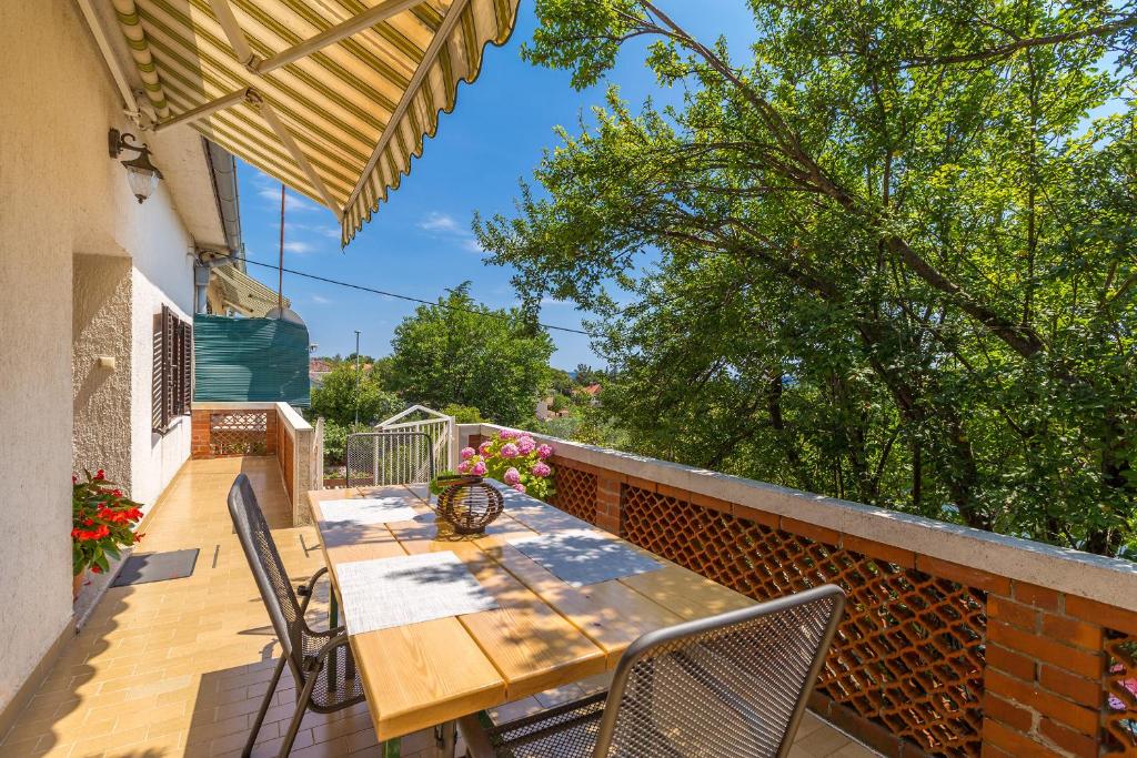 drewniany stół i krzesła na balkonie w obiekcie Apartments Krc w mieście Pinezići