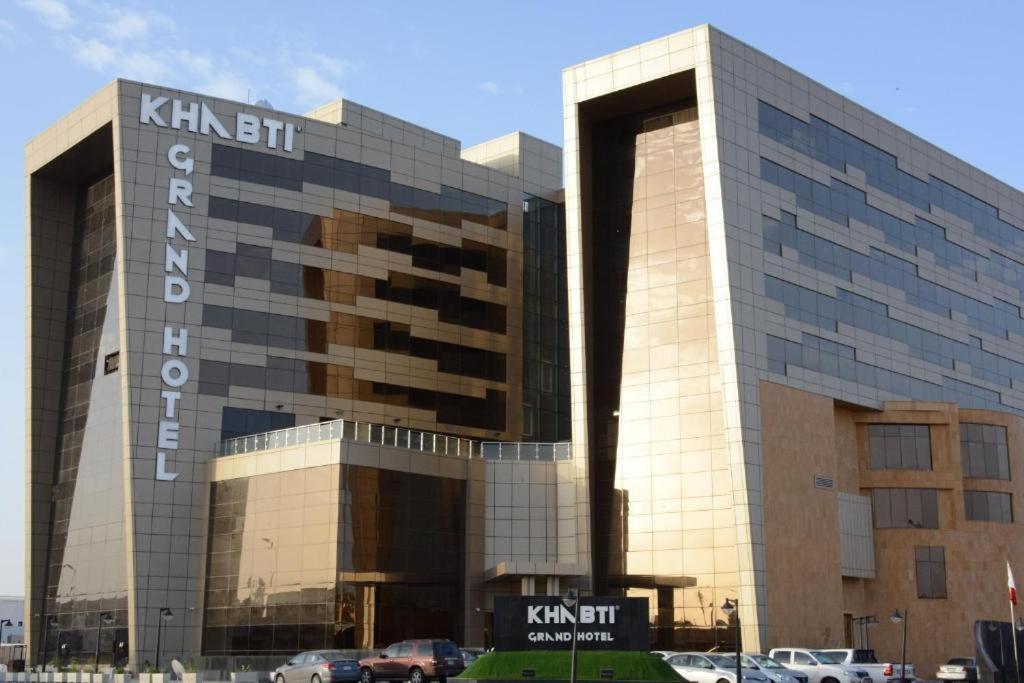 un gran edificio con coches estacionados frente a él en Khabti Grand Hotel, en Qal'at Bishah