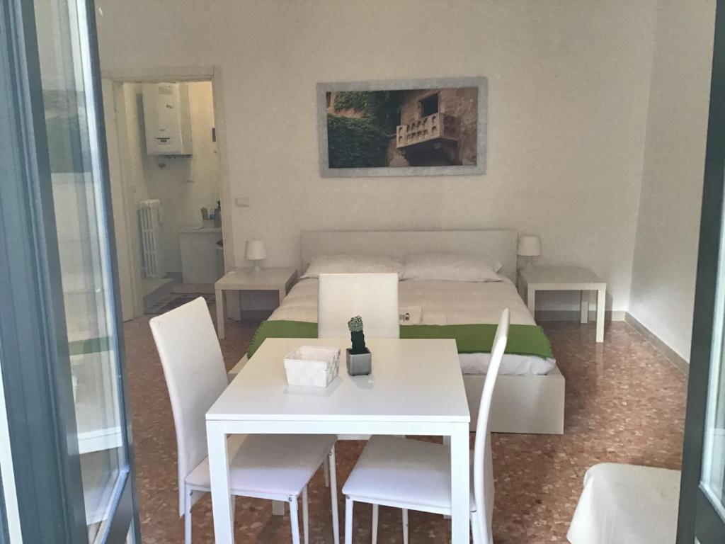 Zimmer mit einem Bett, einem Tisch und Stühlen in der Unterkunft A due passi da Giulietta-Casa Capuleti in Verona