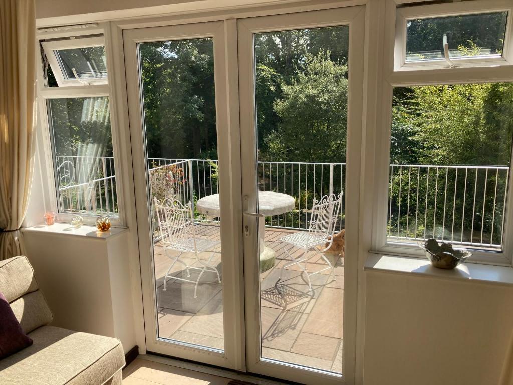 un porche cubierto con puertas correderas de cristal en Woodland Views, en Milton Abbas