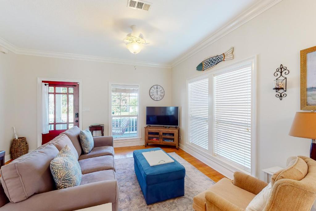 a living room with a couch and a tv at Sunday House in Pensacola