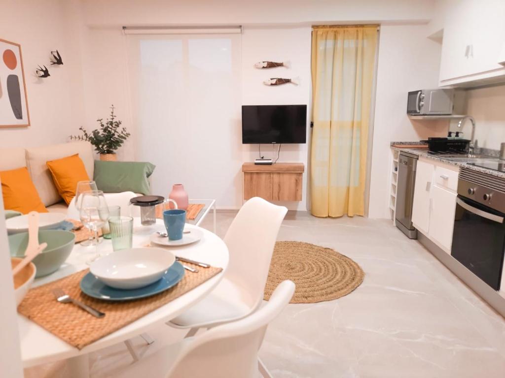 kuchnia i salon ze stołem i krzesłami w obiekcie Bonefish Apartment w mieście Villajoyosa