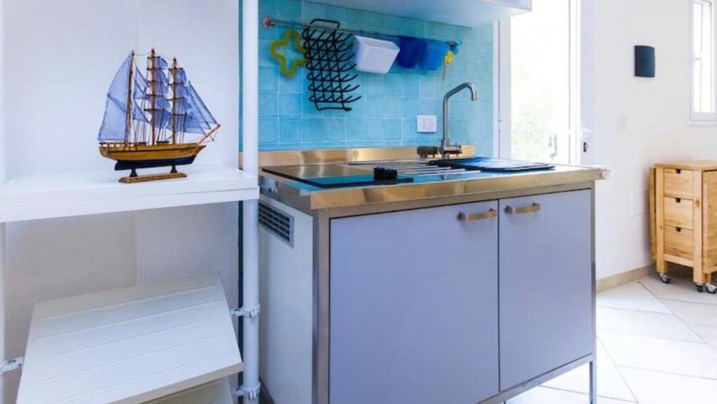 eine Küche mit einem Waschbecken und einem Miniaturboot an der Wand in der Unterkunft Carloforte Bellavista in Carloforte