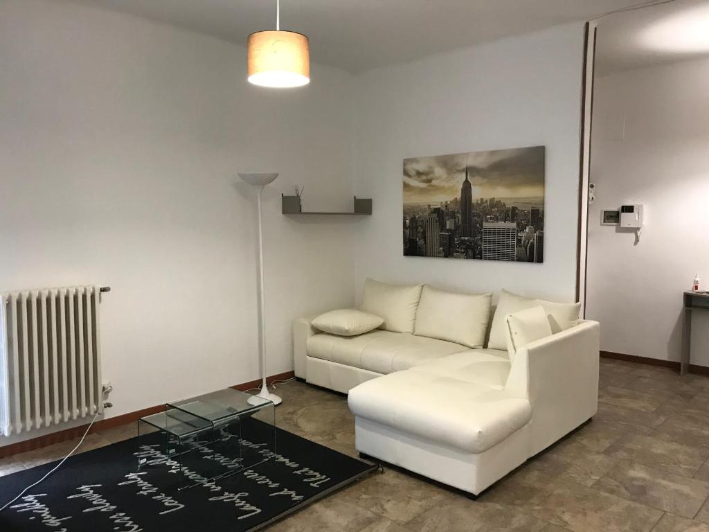 sala de estar con sofá blanco y mesa en L'Alloggio Perfetto, en Putignano