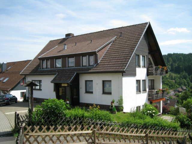 een groot wit huis met een bruin dak bij Appartementhaus Looss in Altenau