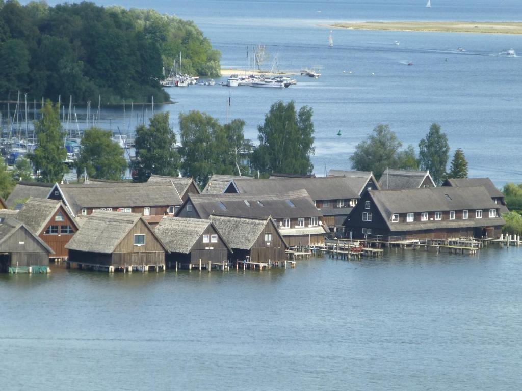 un grupo de casas en el agua con un barco en Zwei Seen Ferienhaus, en Canow