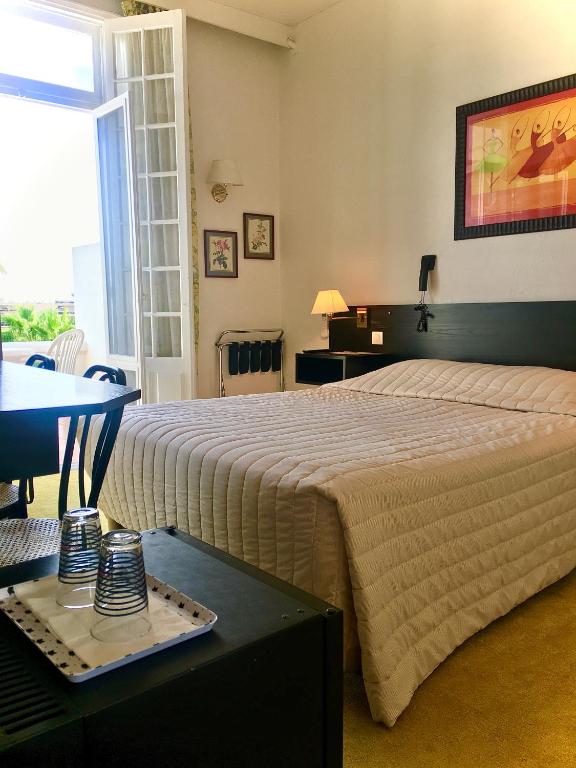 Postel nebo postele na pokoji v ubytování Hotel des Mimosas
