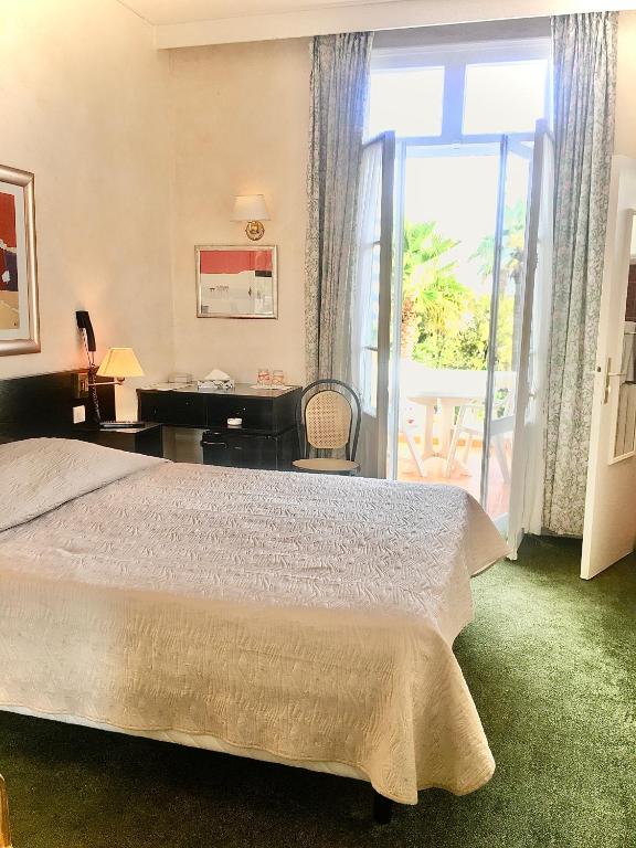 Postel nebo postele na pokoji v ubytování Hotel des Mimosas