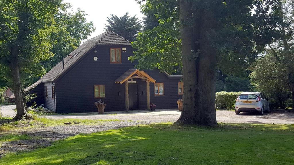 a black house with a car parked in front of it at Oakside Lodge Guest House in Canterbury