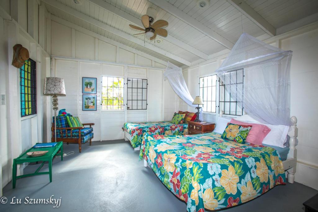 a bedroom with two beds and a ceiling fan at Veranda View Guesthouse in Calibishie