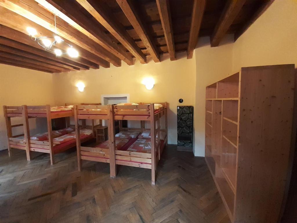 a room with three bunk beds and a wooden floor at Hostel Skautský dom in Banská Štiavnica