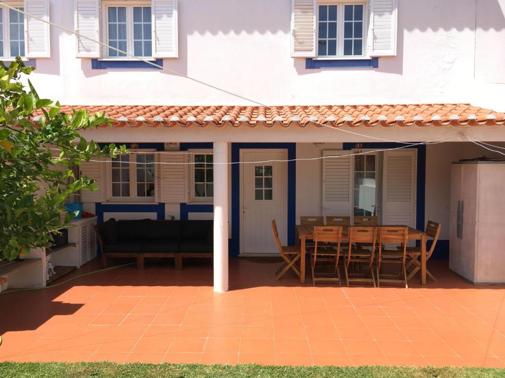 Cette maison dispose d'une terrasse avec une table et des chaises. dans l'établissement Casa do Almograve, à Almograve