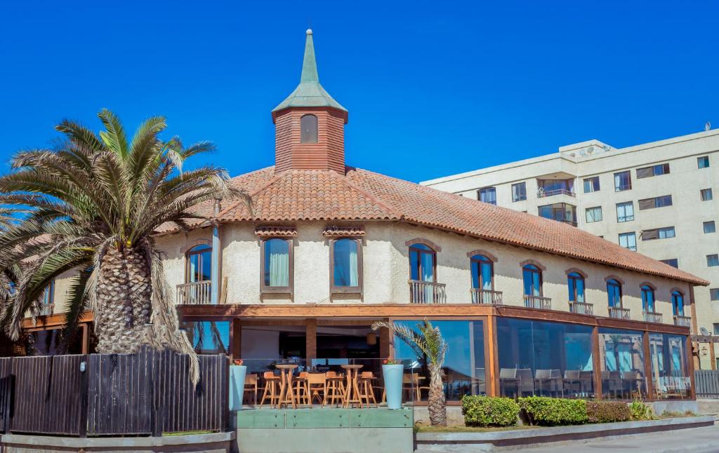 an old building with a turret and a palm tree at Hotel Campanario Del Mar in La Serena