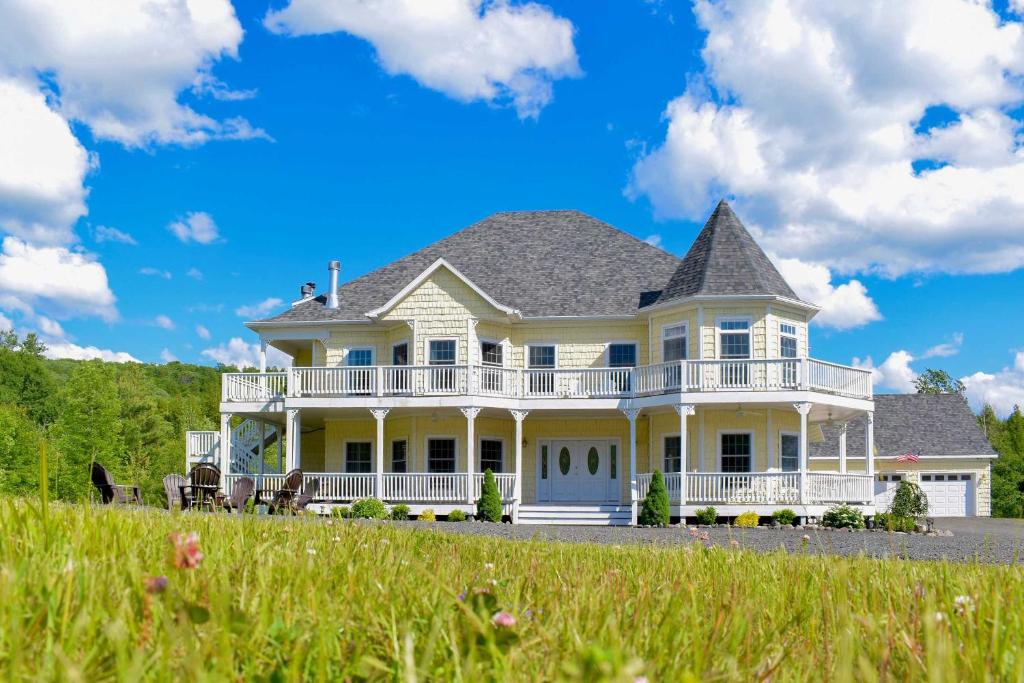een groot wit huis met een veranda en een gazon bij Windham Manor on 45 Acres - 5 Mi to Ski Resort! in Windham