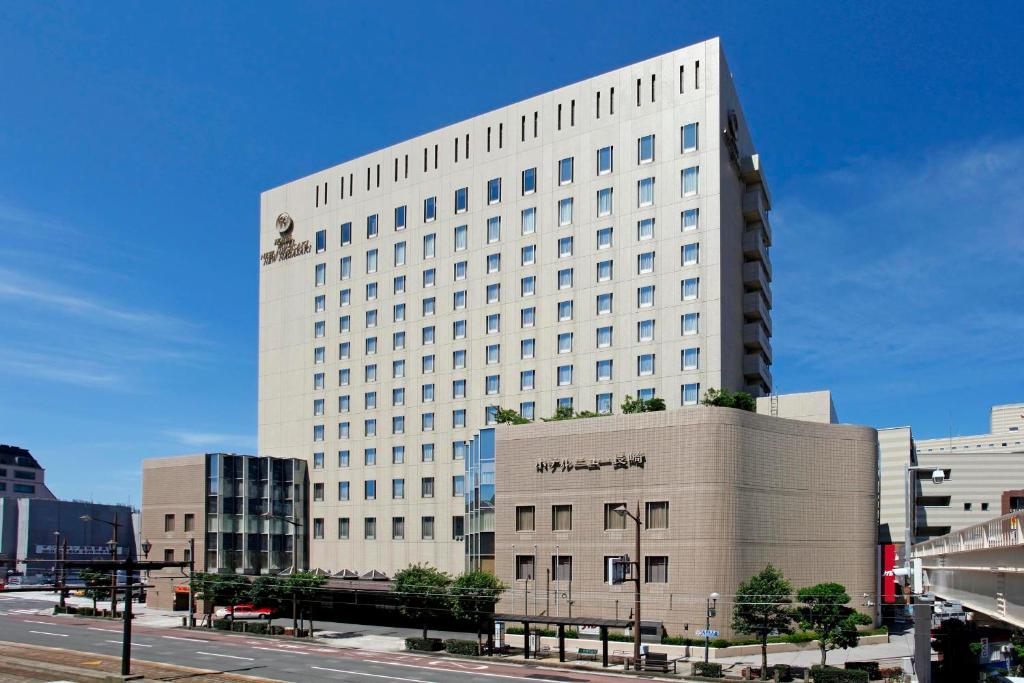 a large white building in the middle of a city at Hotel New Nagasaki in Nagasaki