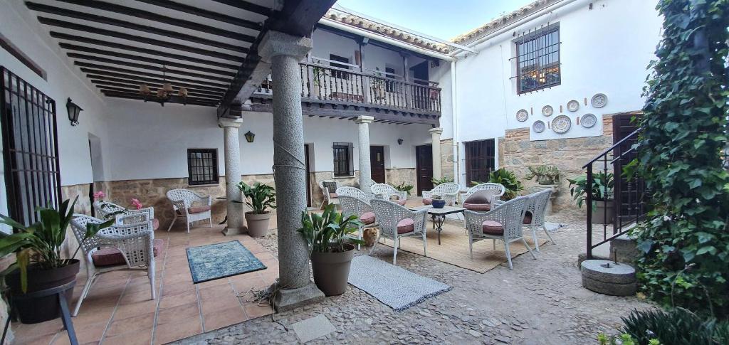 an outdoor patio with chairs and tables and plants at Casa Cuqui in Orgaz