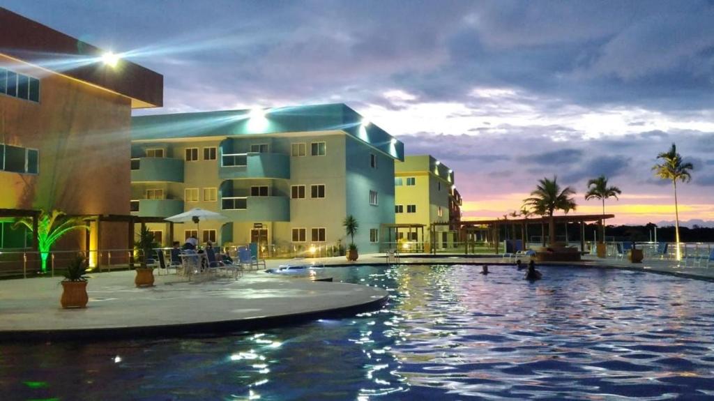 ein Hotel mit einem Pool vor einem Gebäude in der Unterkunft Golden Lake Residence in Arraial do Cabo