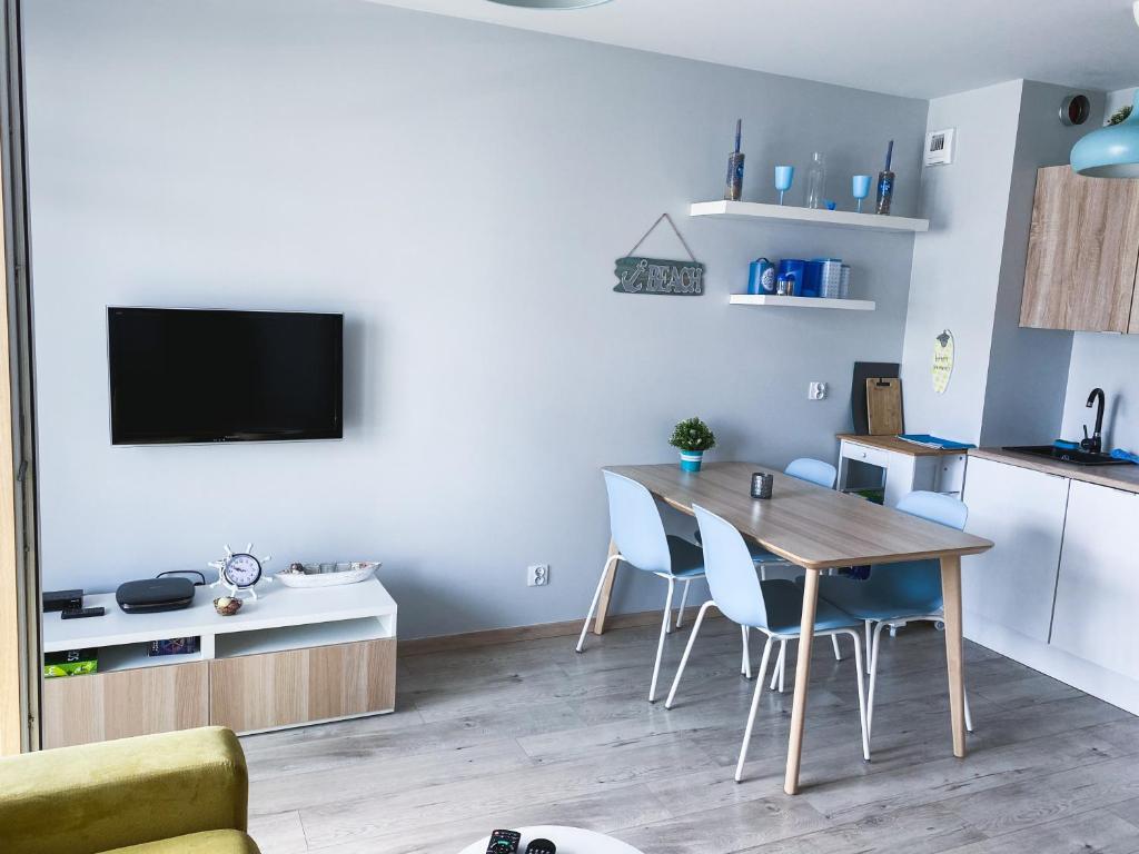 a kitchen and dining room with a table and chairs at Słoneczne Tarasy by Marta in Dziwnówek