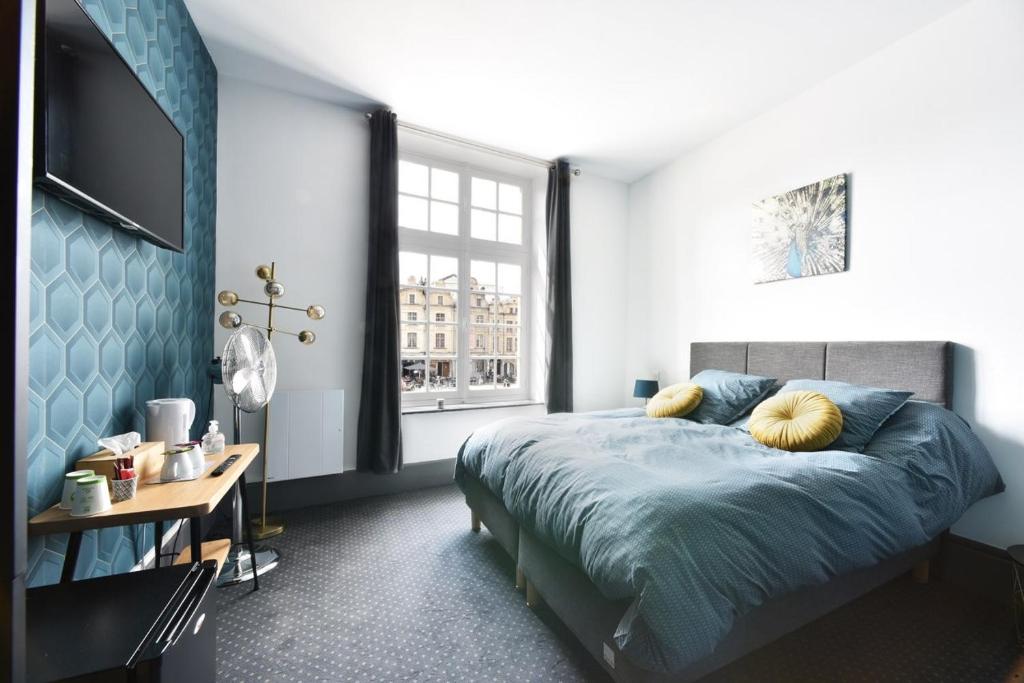 sypialnia z łóżkiem i dużym oknem w obiekcie La cour des grands w mieście Arras
