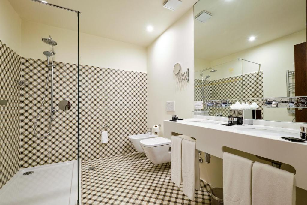 a bathroom with a toilet and two sinks and a shower at Sintra Boutique Hotel in Sintra